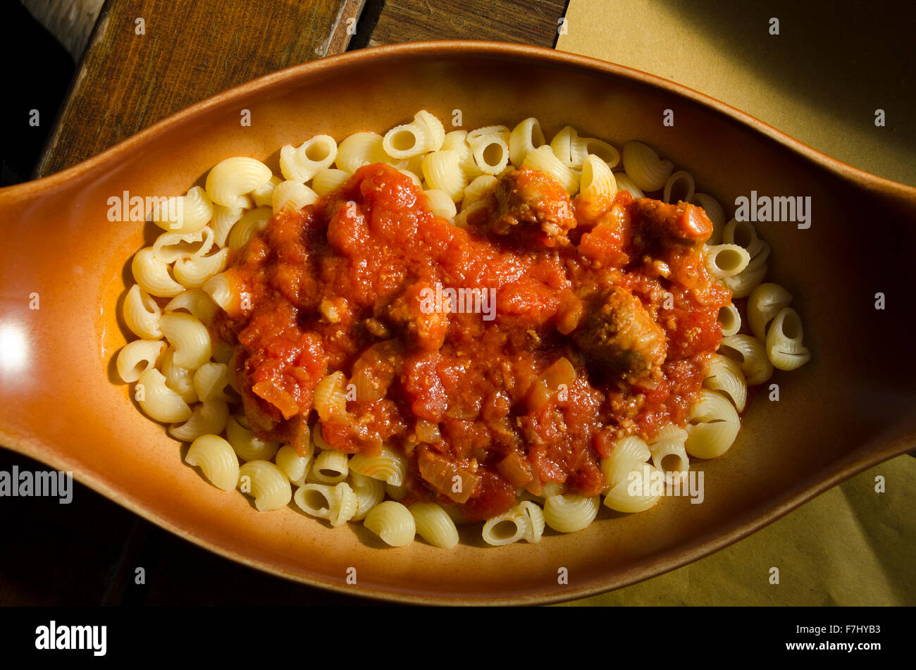 pasta with sausage sauce in a dish of baked earth Stock Photo