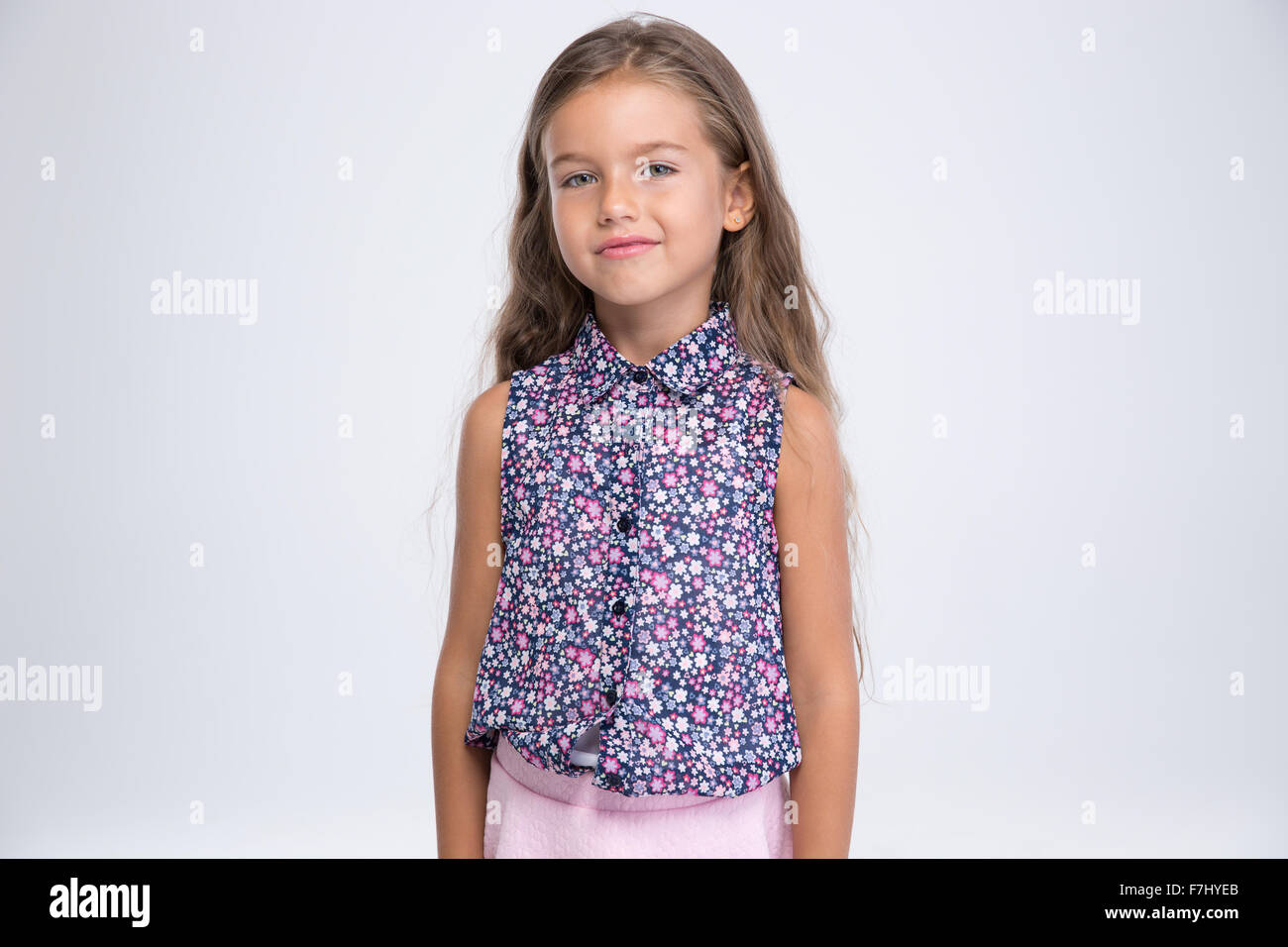 Portrait of a pretty little girl looking at camera isolated on a white ...