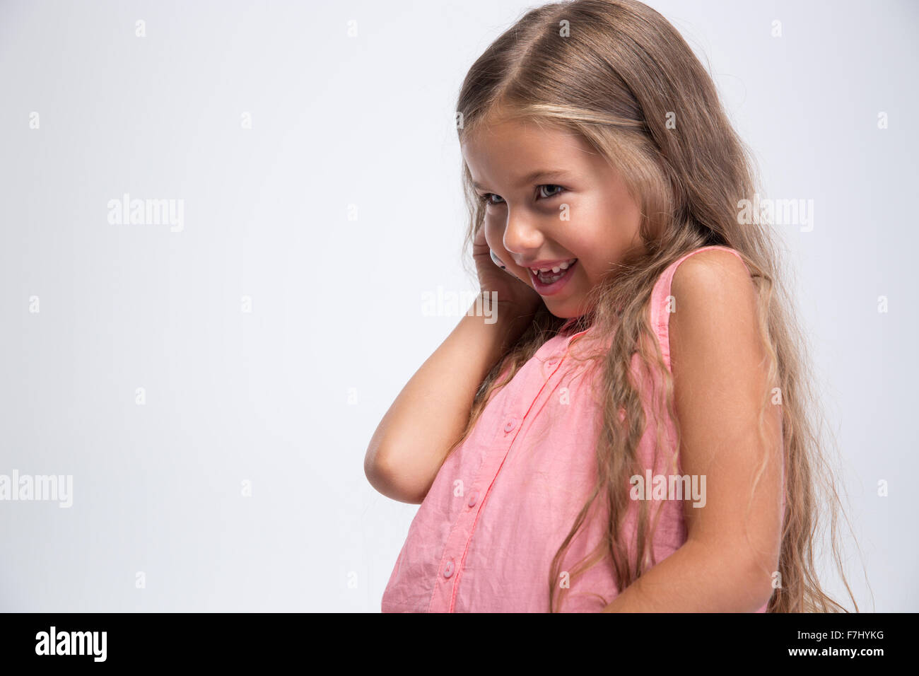 Portrait of a cute little girl talking on the phone isolated on a white ...