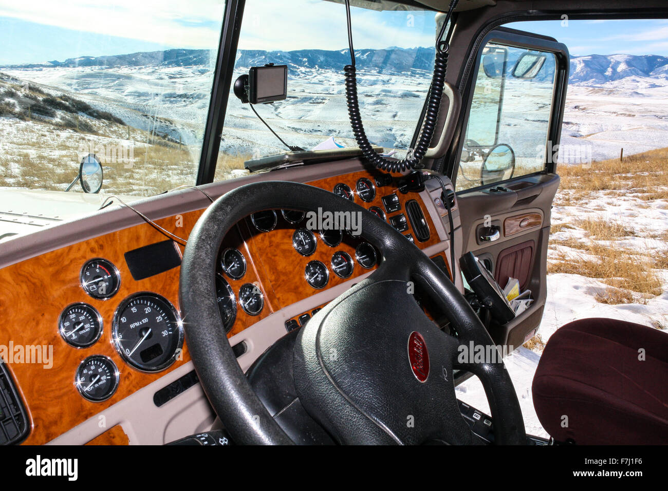 Wyoming, USA view from cab of Peterbilt 379 truck parked in a pull out scenic view with dashboard and snowy hills in background Stock Photo