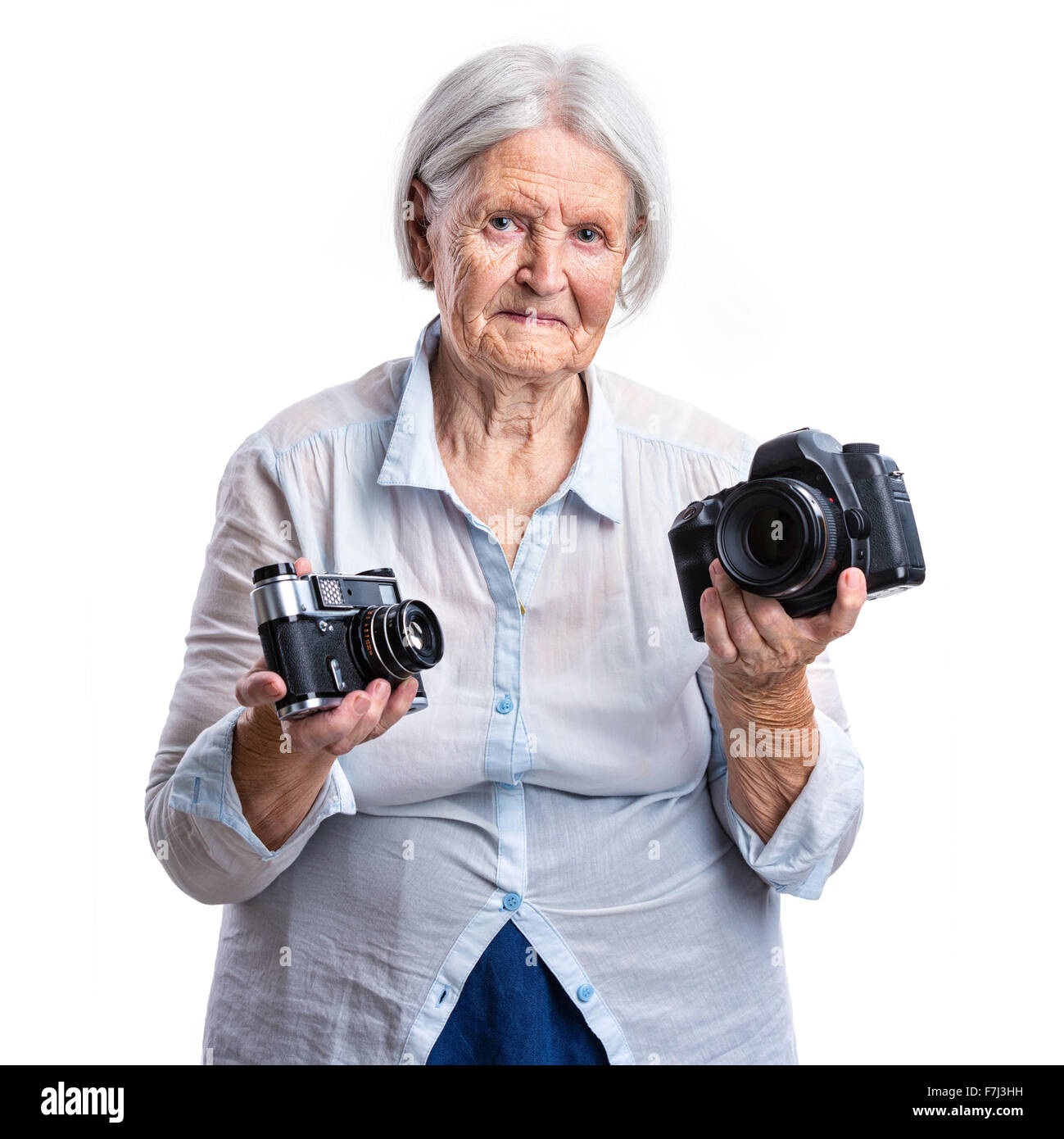 Senior woman holding old analogue and modern digital cameras in hands, choice concept Stock Photo