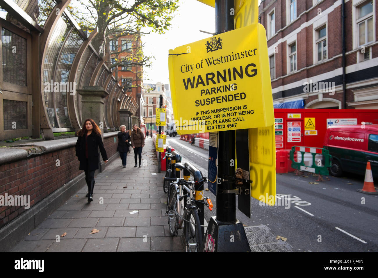 Yellow signs by the City of Westminster warning that the parking bay is suspended in Wardour Street, Soho, London, England, UK Stock Photo