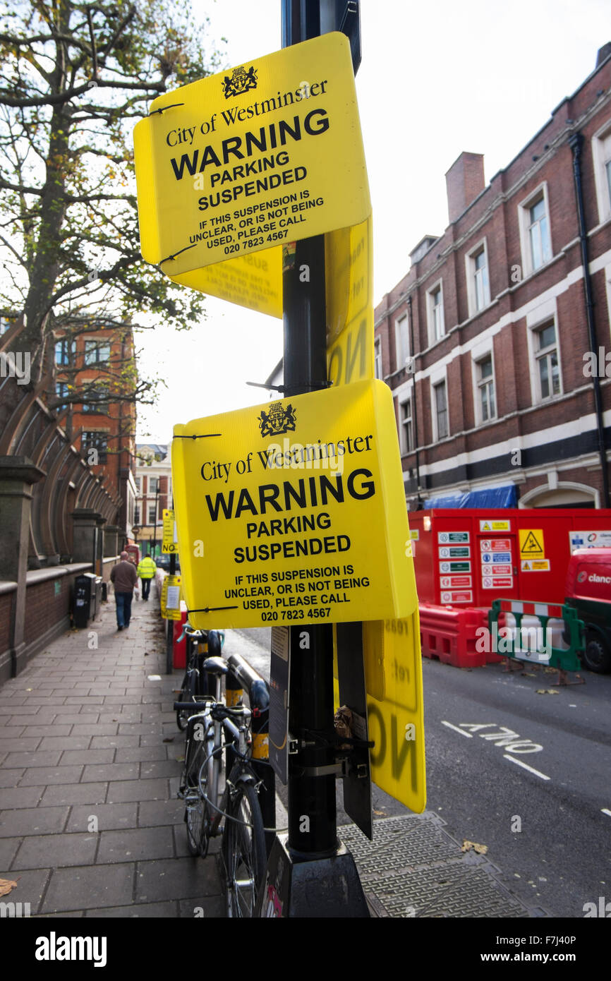 Yellow signs by the City of Westminster warning that the parking bay is suspended in Wardour Street, Soho, London, England, UK Stock Photo