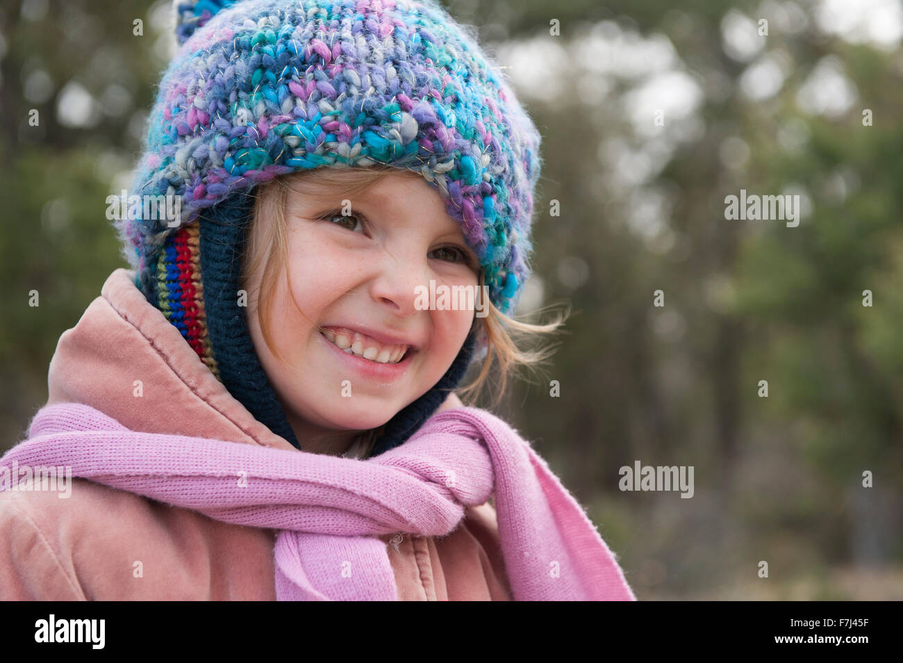 Little girl wearing knit hat and scarf, smiling, portrait Stock Photo