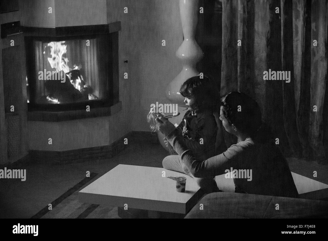 mother child daughter home fireplace room indoor [black and white] Stock Photo