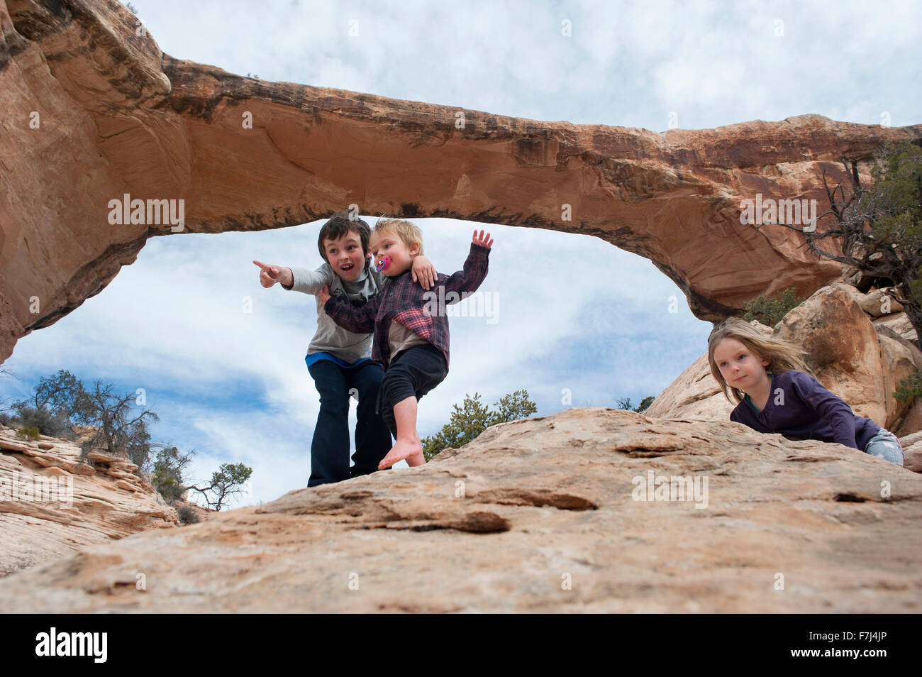 Children exploring near Owachomo Bridge, Natural Bridges National Monument, Utah, USA Stock Photo