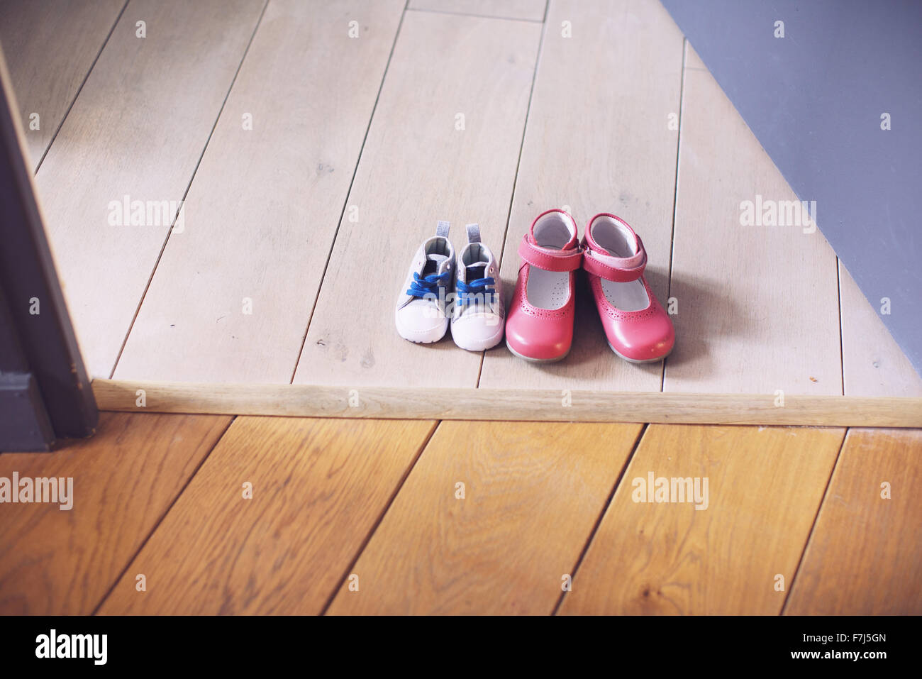 Children's shoes side by side on floor Stock Photo