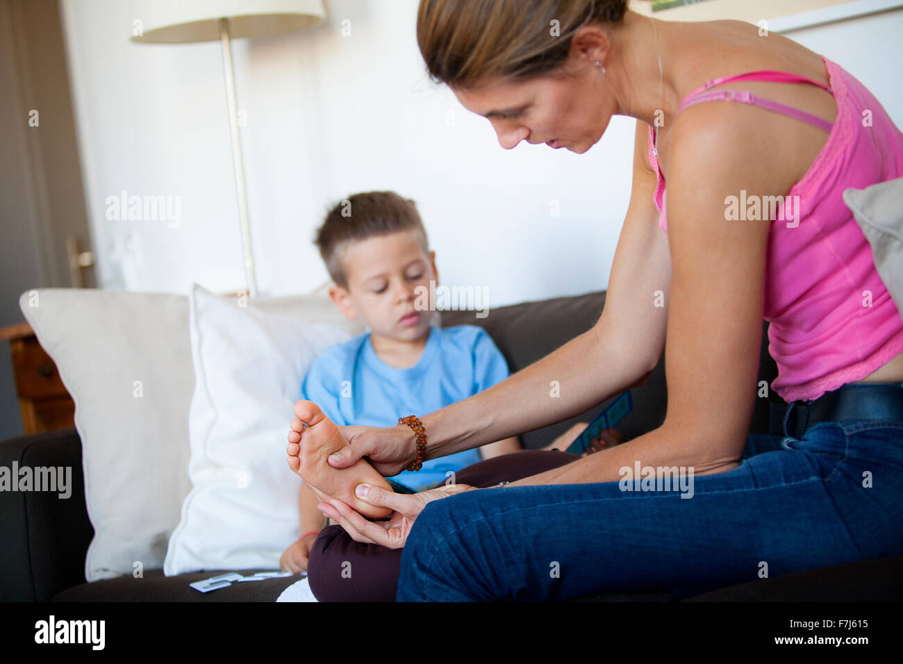 Reportage on foot reflexology for children. The reflexologist deals with children from the age of 5 upwards. Reflexology acts on their concentration, memory, balance, serenity and sleep. A 5-year old boy in a session. Stock Photo