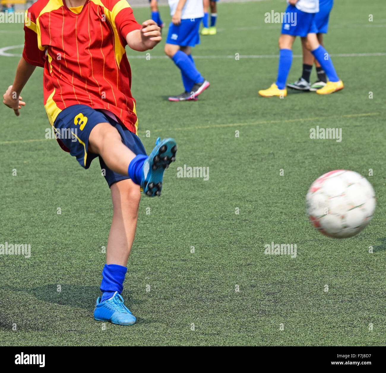 Young soccer player kicks the ball Stock Photo