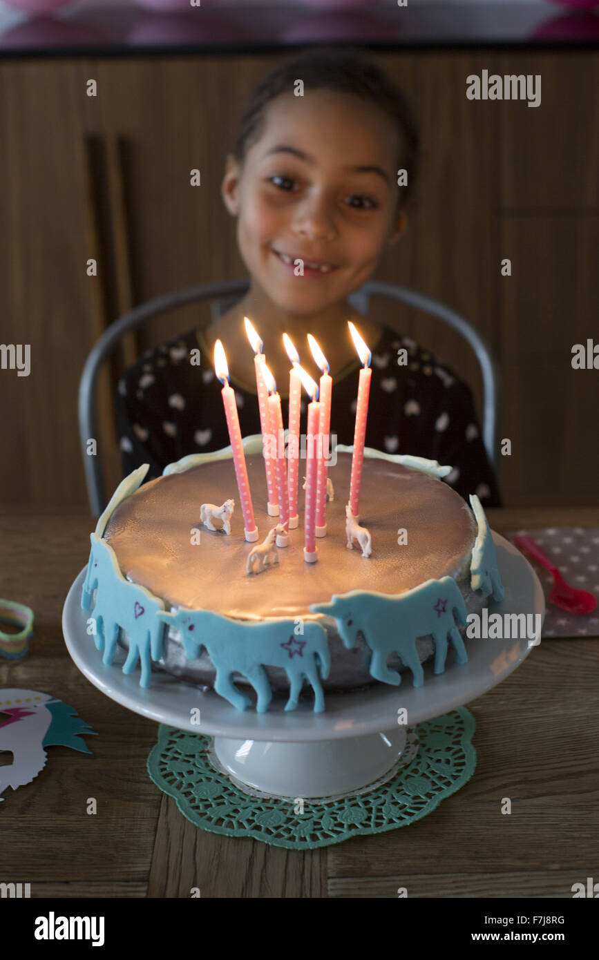 Girl preparing to blow out candles on birthday cake Stock Photo