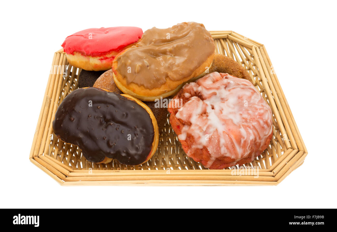 An old wicker basket filled with assorted donuts and iced cherry fritter on a white background. Stock Photo