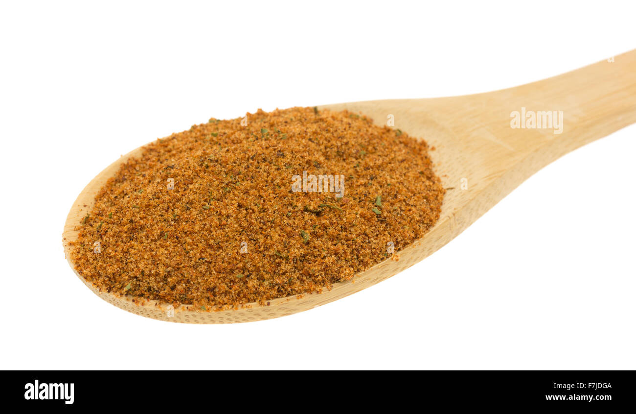 A wood spoon filled with dry chipotle pepper marinade ingredients on a