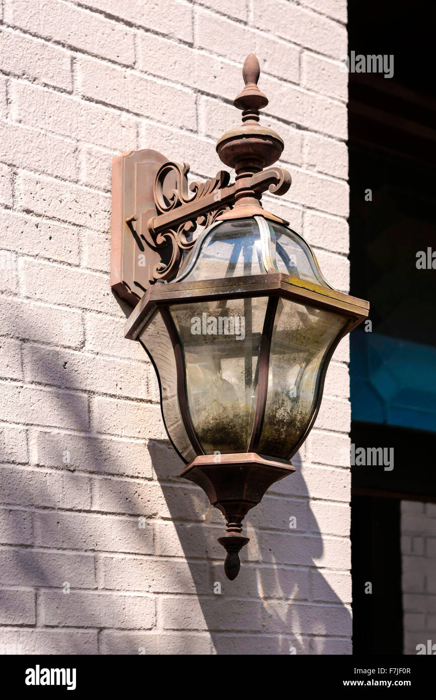 An old rusting gas coach lantern on the wall of an abandoned building Stock Photo