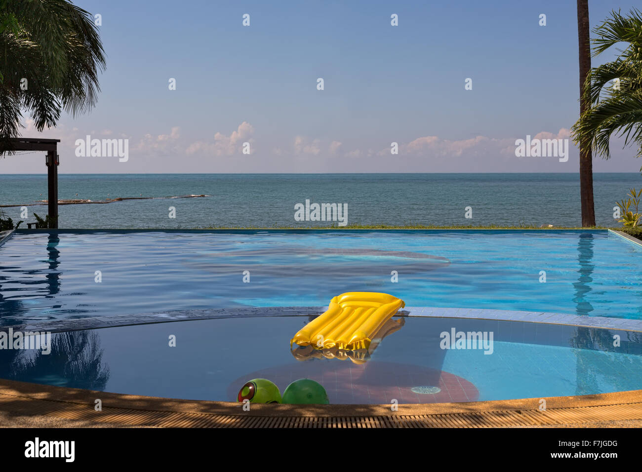 Pool overlooking the sea with yellow inflatable mattress. Stock Photo