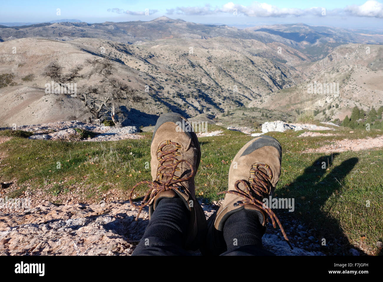 Hiking Boots, Shoes. Mountain range of Sierra de las Nieves in background, Andalusia, Southern Spain. Stock Photo