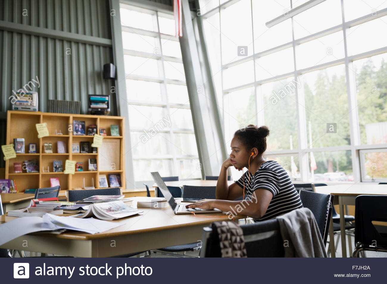 Focused high school student studying at laptop library Stock Photo