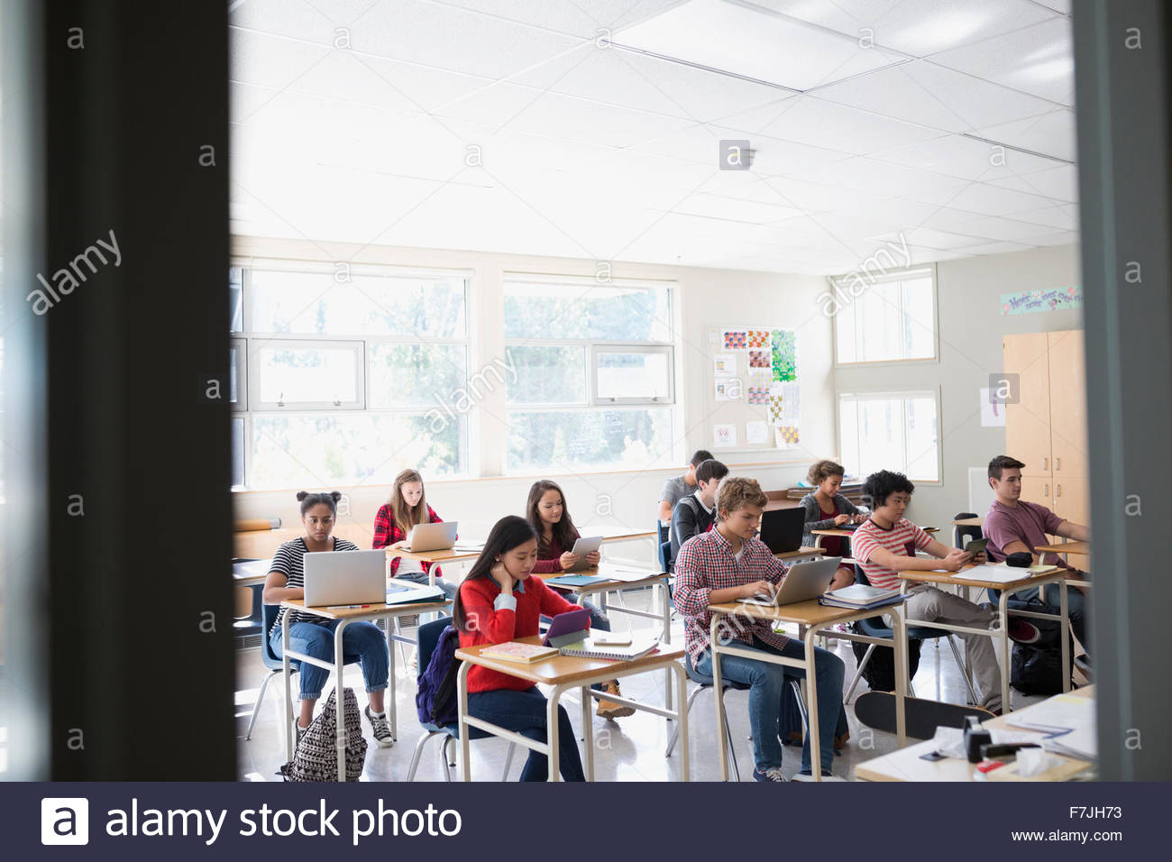 High school students laptops and digital tablets desks Stock Photo