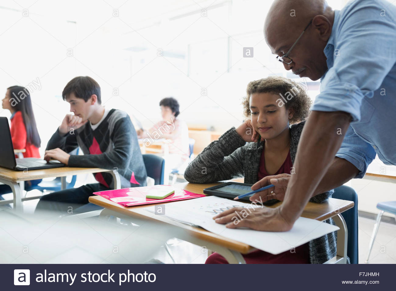 High school teacher helping student with homework desk Stock Photo Alamy
