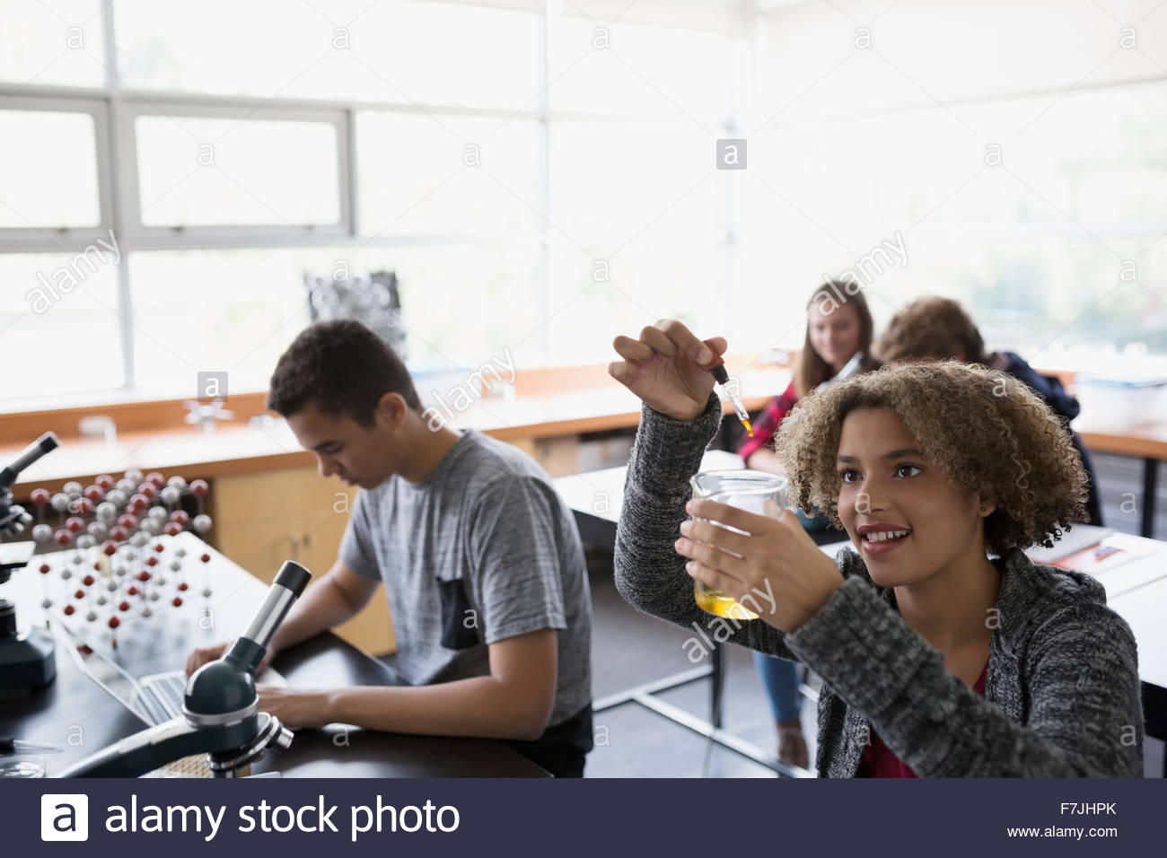 High school student dropping liquid into beaker Stock Photo