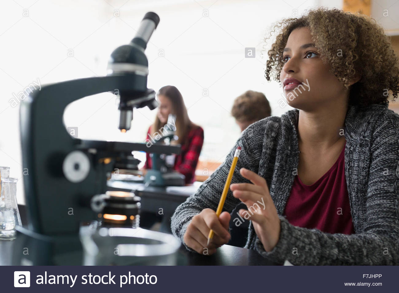 Focused high school student microscope listening science classroom