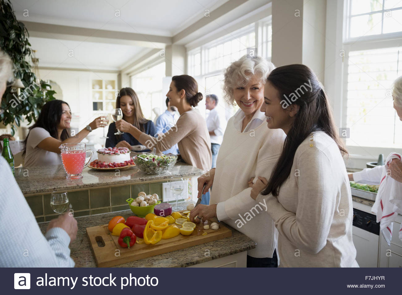 Mother and daughter slicing fruit in kitchen Stock Photo