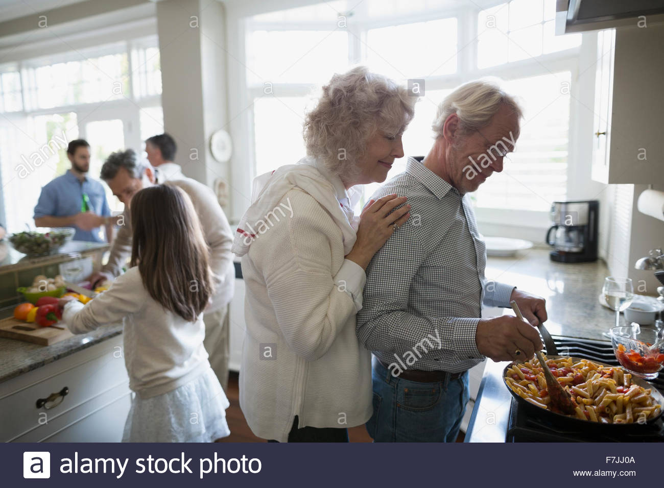 Senior couple cooking at kitchen stove Stock Photo
