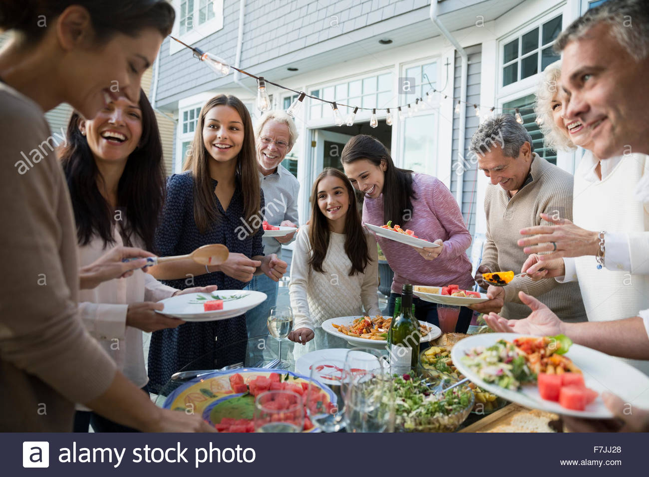 Multi-generation family serving food at buffet patio Stock Photo