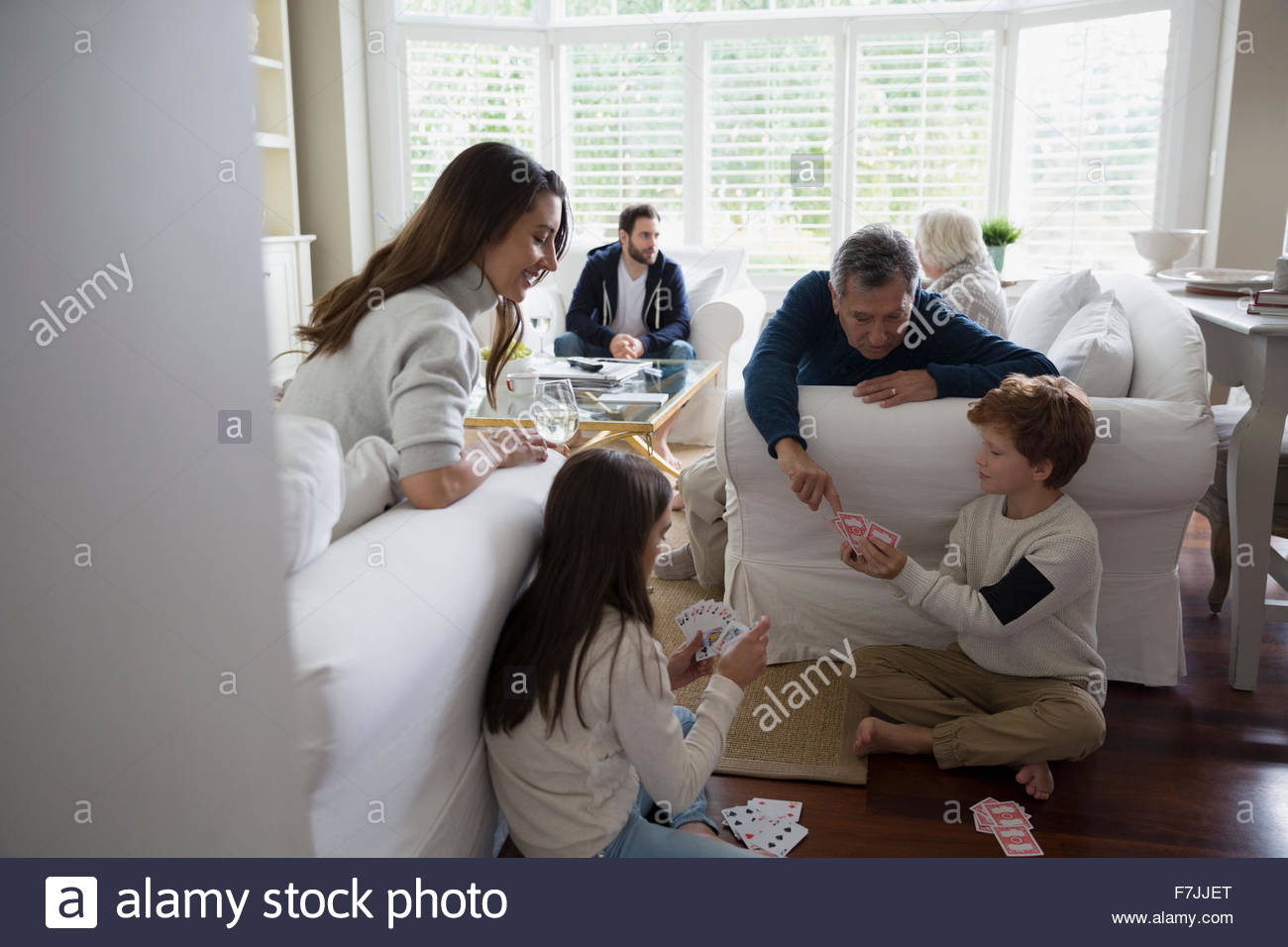 Family playing cards in living room Stock Photo