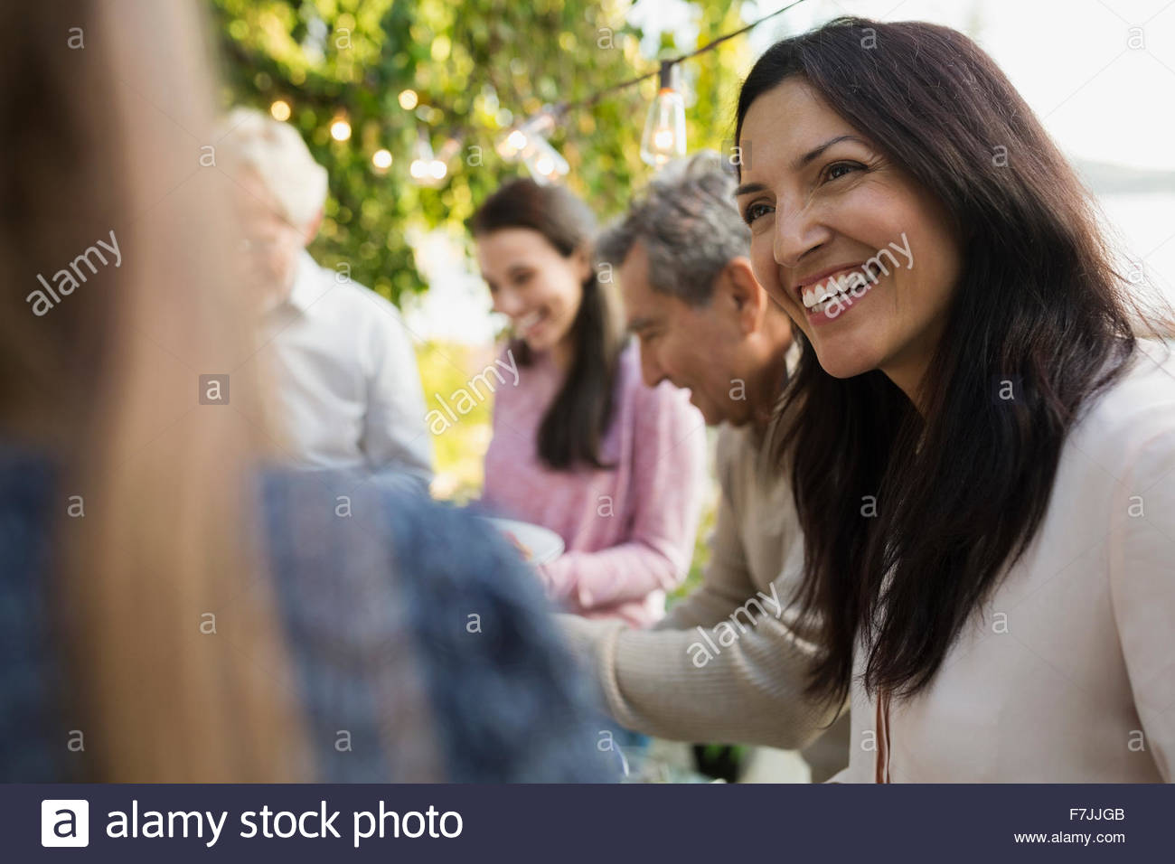 Smiling woman talking at social gathering Stock Photo