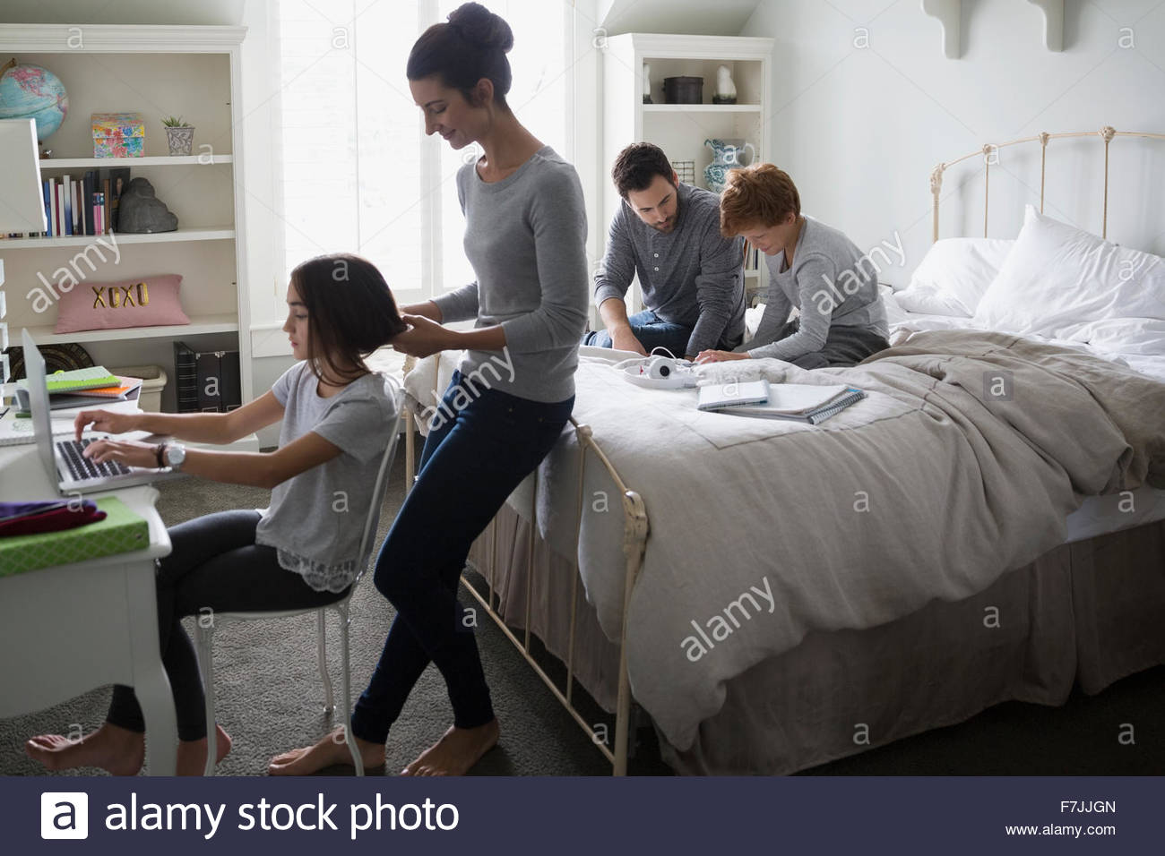 Parents helping children with homework in bedroom Stock Photo