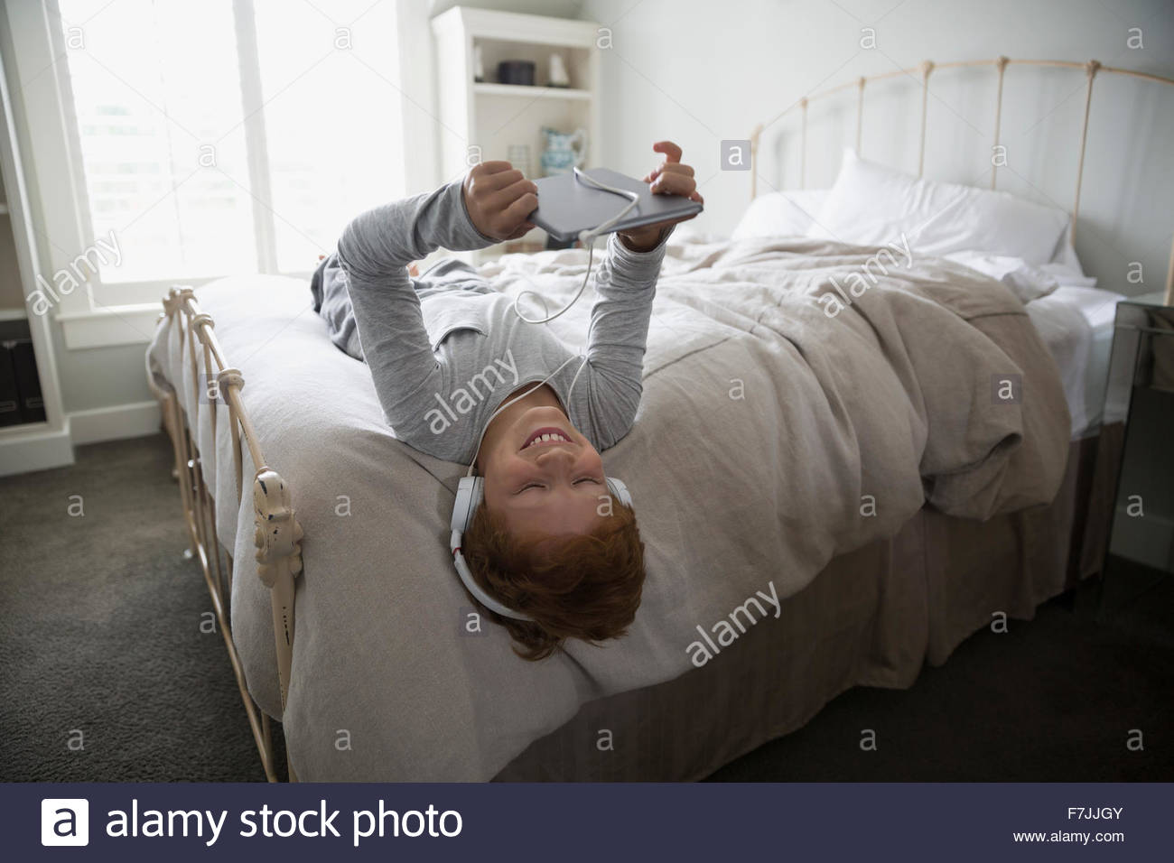 Boy digital tablet listening music headphones upsidedown Stock Photo Alamy