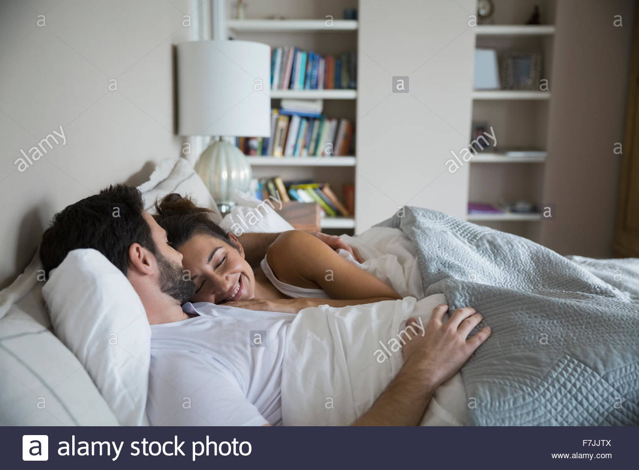 Affectionate couple cuddling in bed Stock Photo