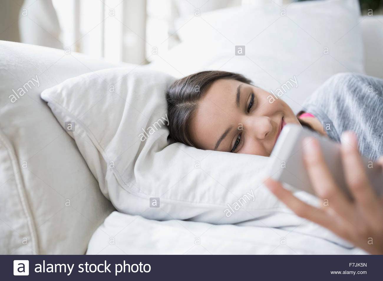 Relaxed teenage girl texting cell phone sofa Stock Photo