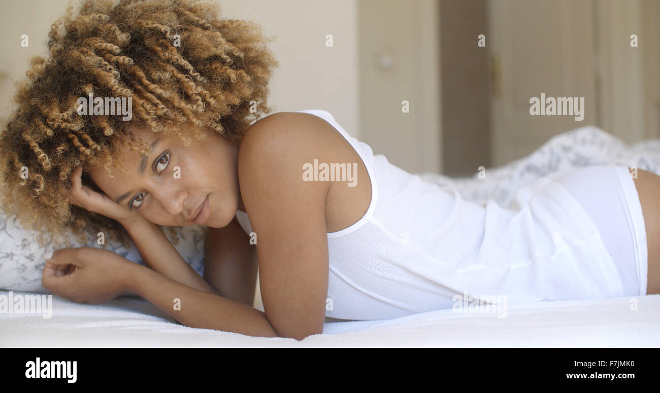Beautiful African American Woman Lying On Bed Stock Photo