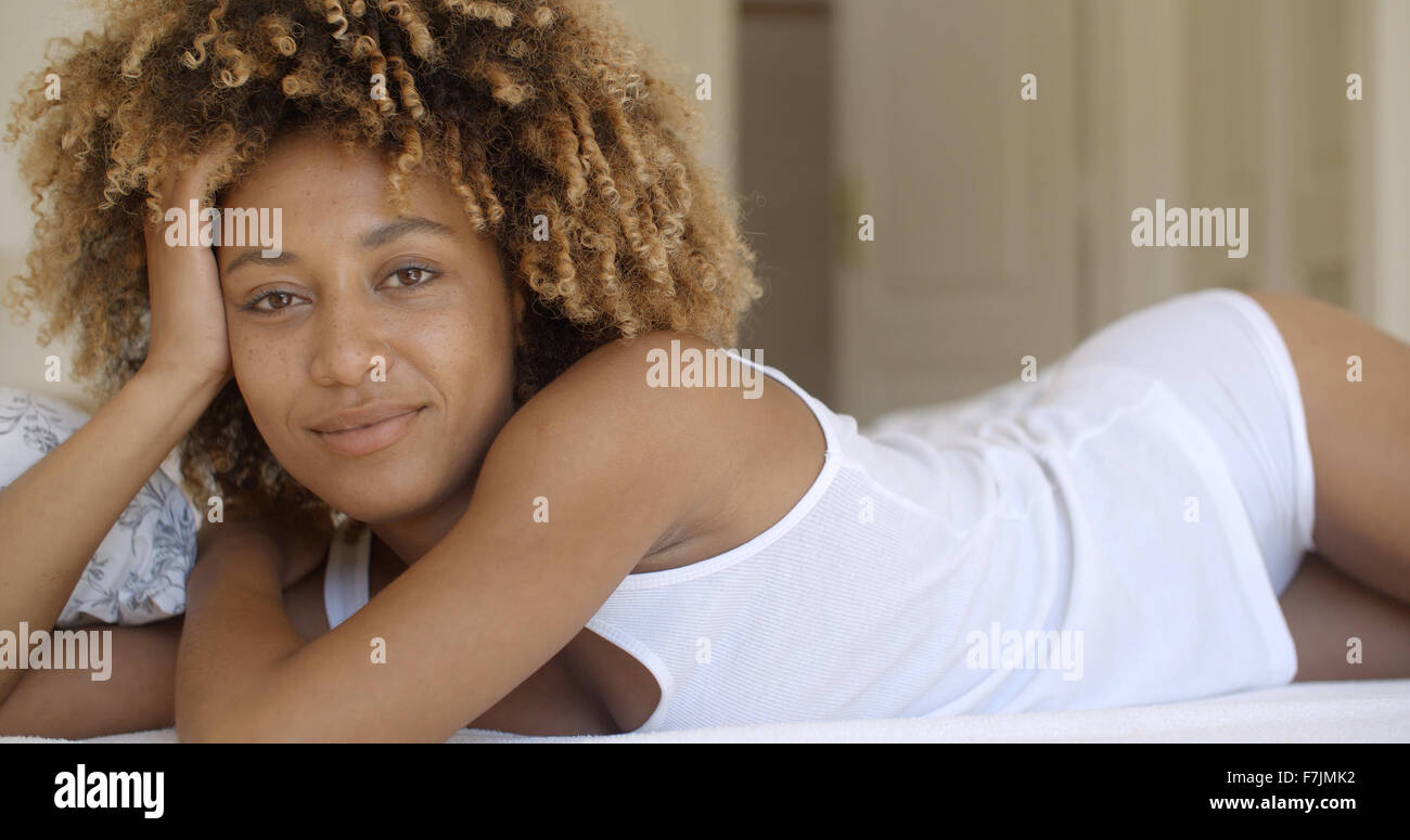 Beautiful African American Woman Lying On Bed Stock Photo