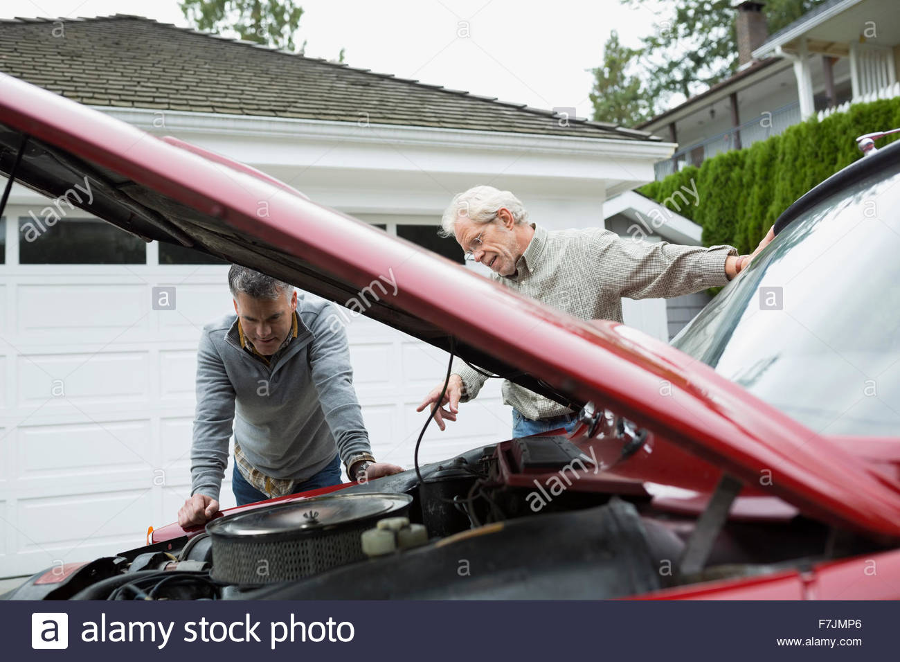 Father and son checking engine classic car driveway Stock Photo