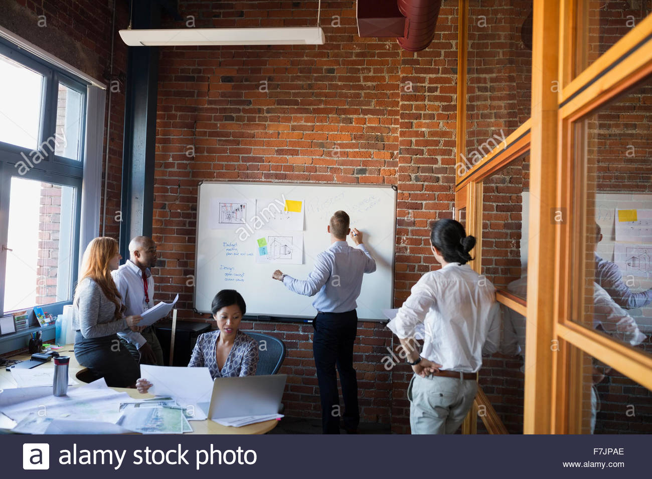 Business people meeting at whiteboard in conference room Stock Photo
