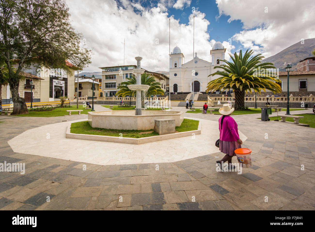 Traditionally dressed Peruvian woman walks through main square of town of Cajabamba in Cajamarca region of Peru Stock Photo