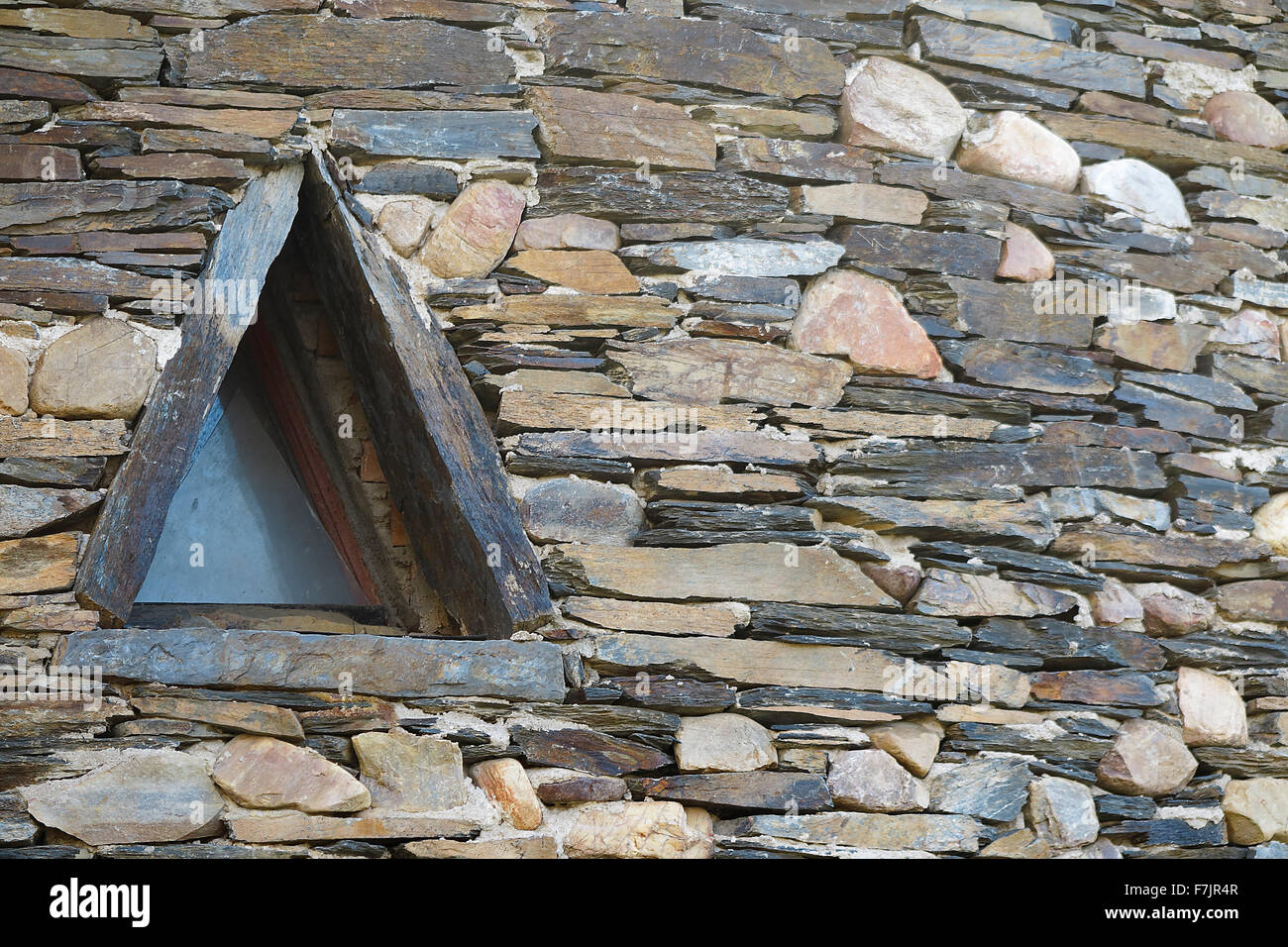triangular window in a wall built of slate, typical of the villages of ...