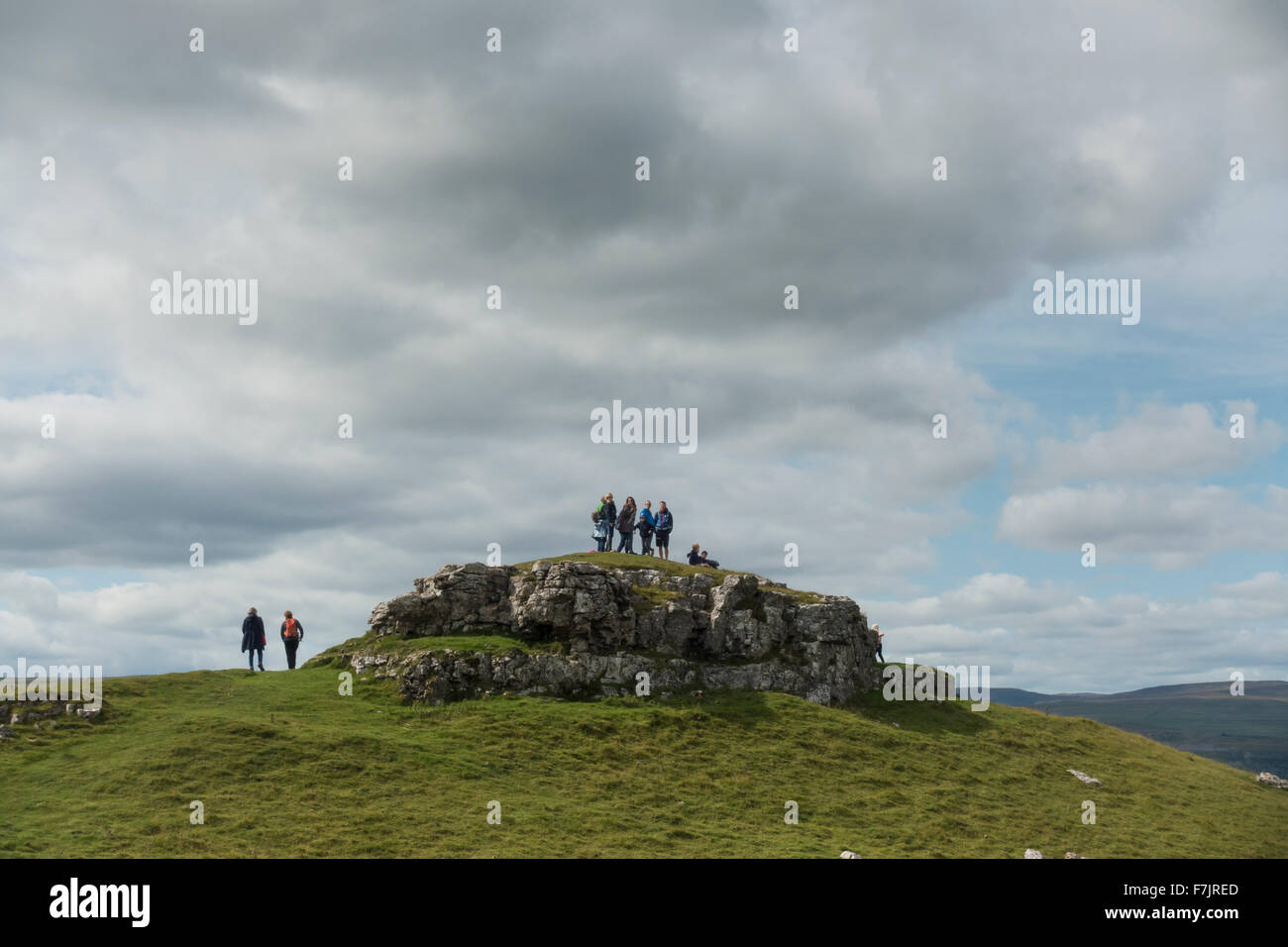 Yorkshire Dales upland, limestone scenery - People stand high, on top of Conistone Pie (rocky outcrop) admiring the rugged landscape. England, GB, UK. Stock Photo