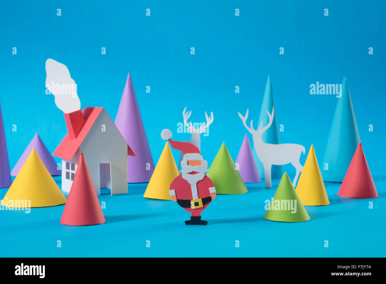 Christmas paper cut house with handmade santa and deers on colorful blue background. Ideal for xmas greeting card, holiday Stock Photo