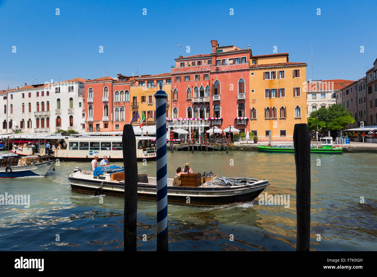 Venice, Italy.  Traffic on the Grand Canal.  Boats delivering goods.  In background, a vaporetto, or waterbus. Stock Photo