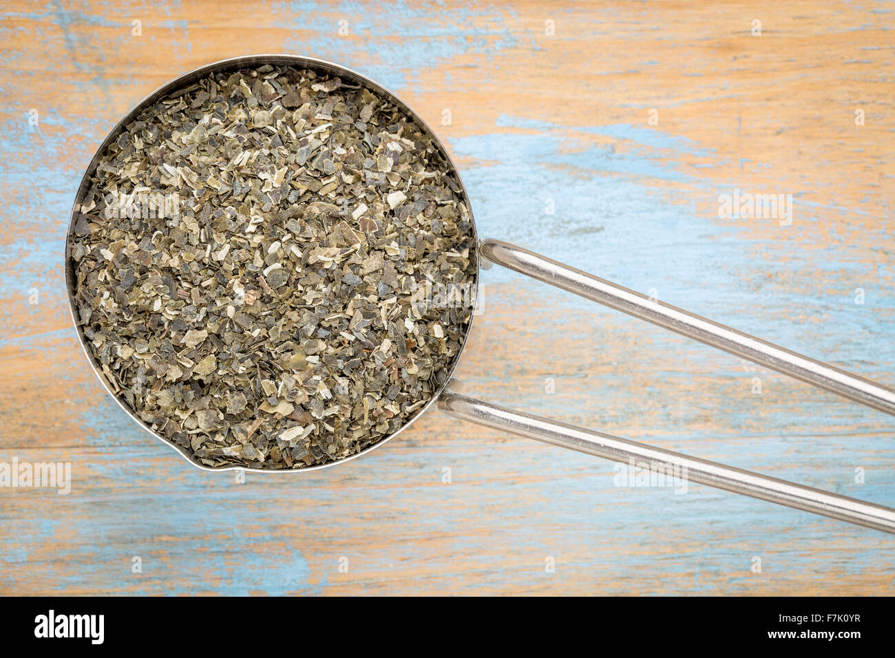 dried wakame seaweed - top view of a metal measuring scoop against painted wood Stock Photo