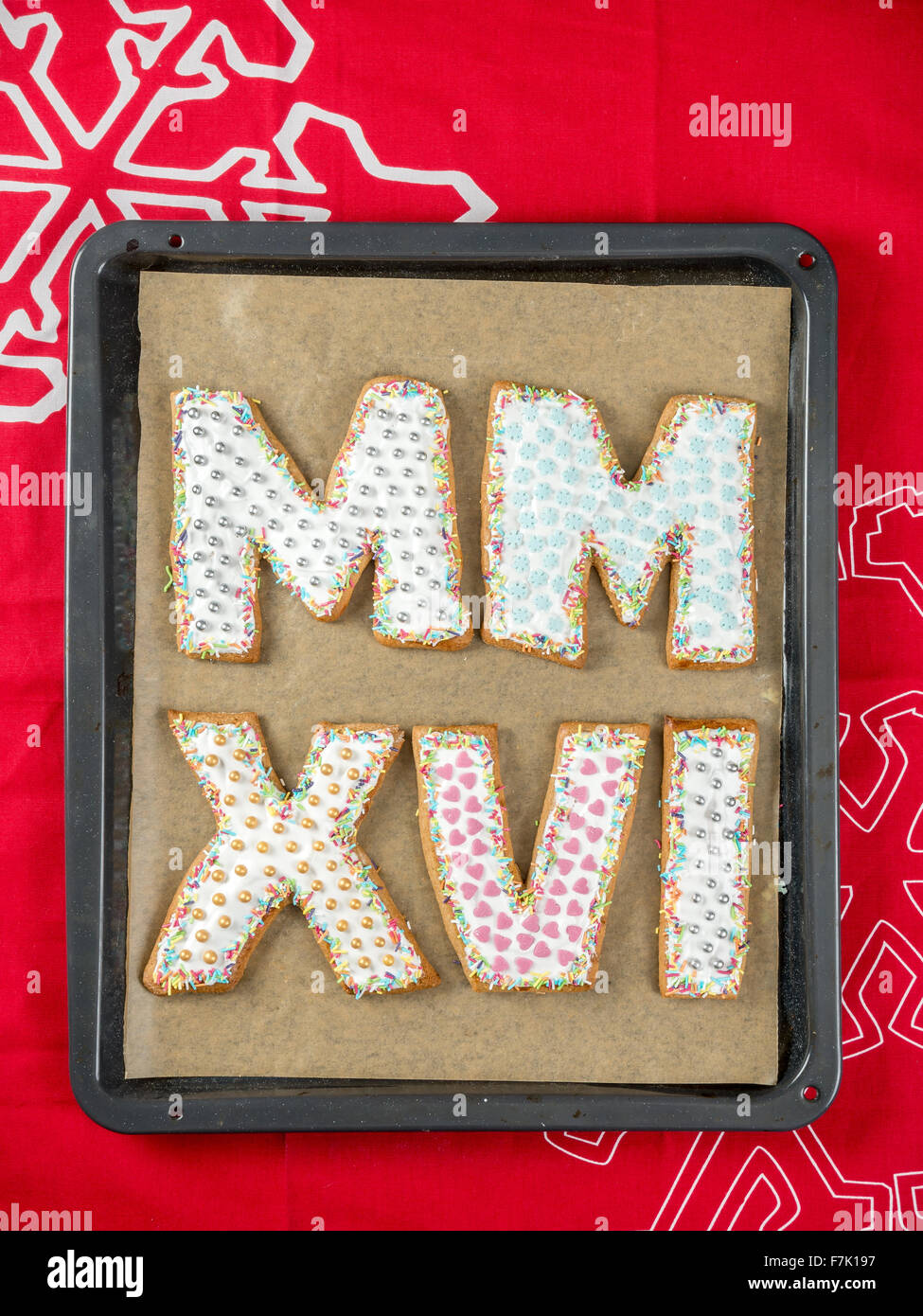 Home-made gingerbread cookies in shape of Roman numerals representing 2016 New Year date on baking tray Stock Photo