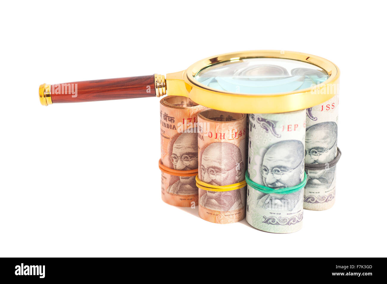 Rolls of Indian Currency Rupee Notes with magnifying glass isolated on ...