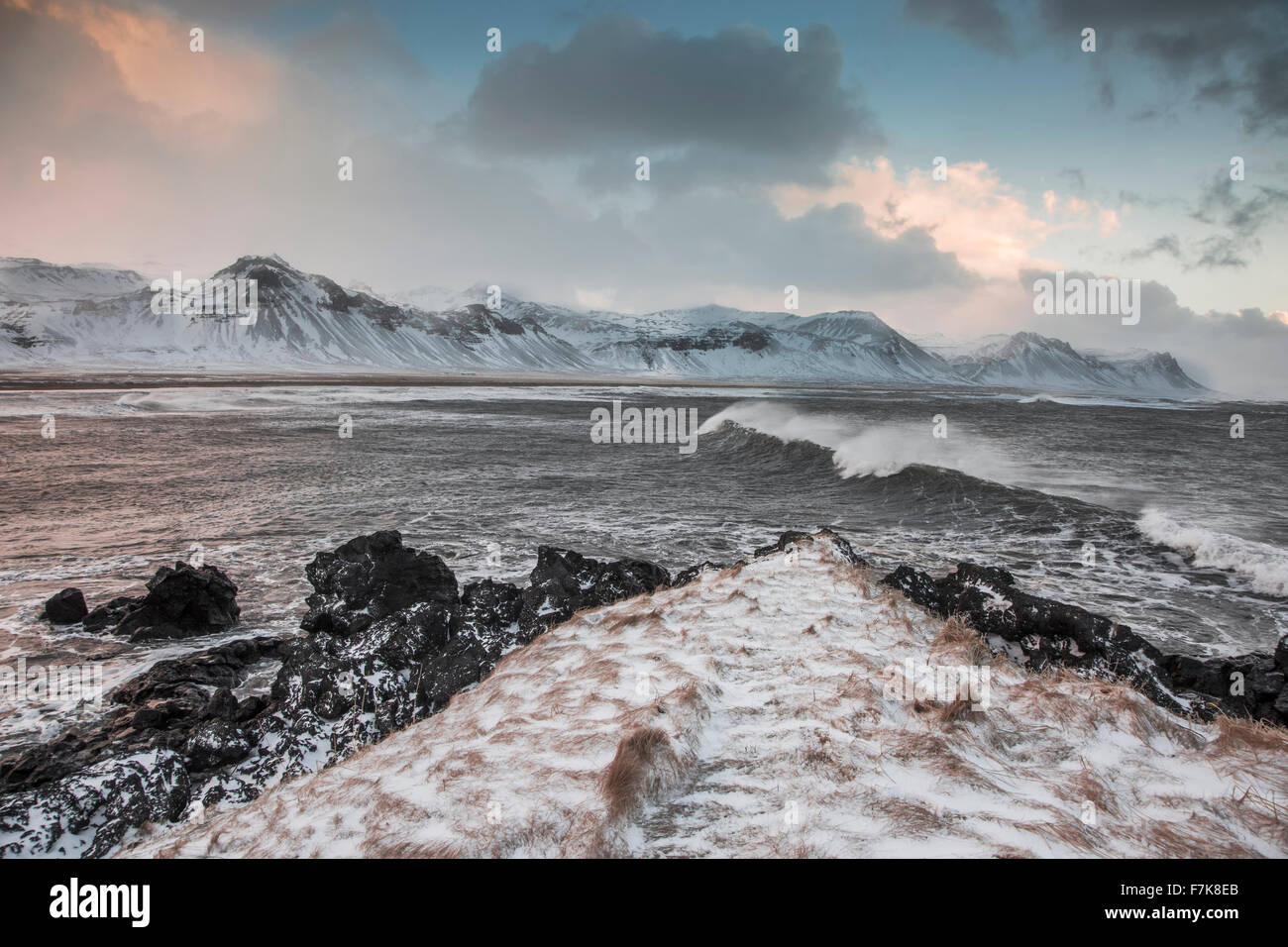 Snow covered mountain range over cold ocean, Budir, Snaefellsnes, Iceland Stock Photo