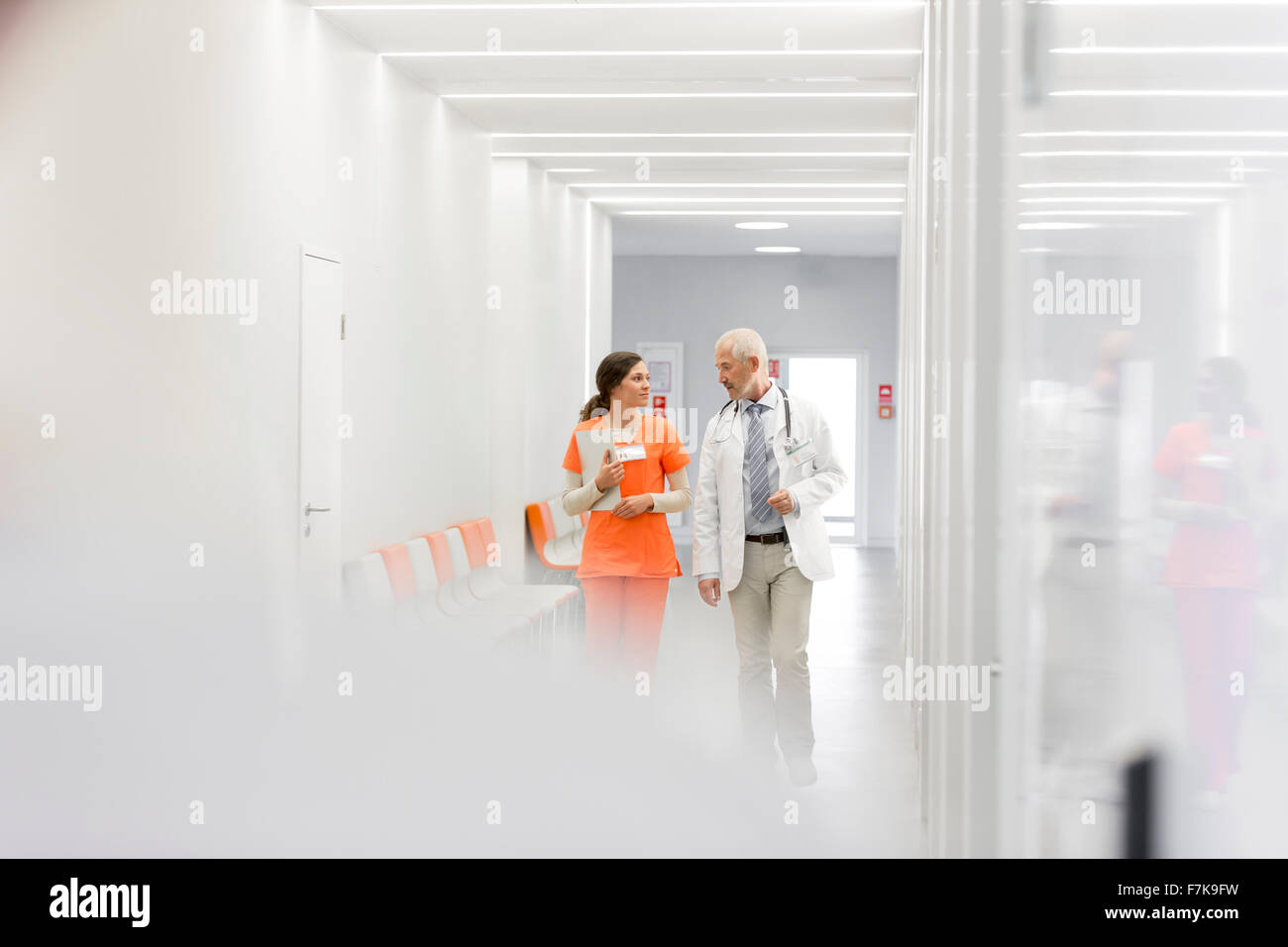 Doctor and nurse making rounds in hospital corridor Stock Photo