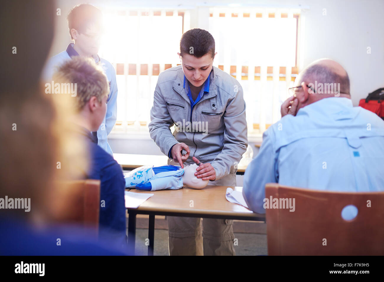 Instructor with CPR dummy teaching first aid class Stock Photo