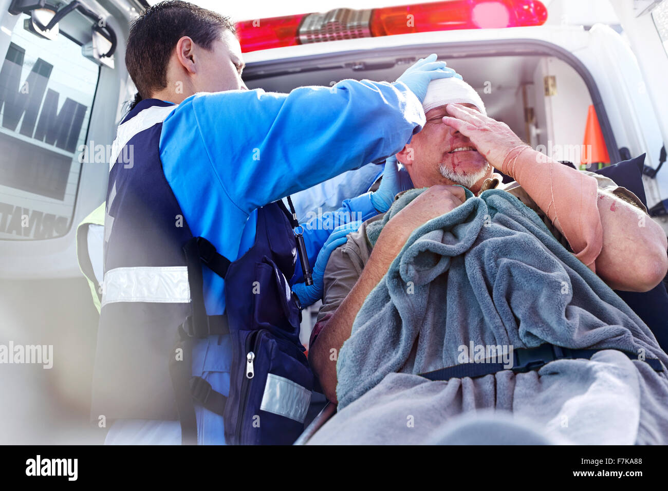 Rescue worker tending to patient at back of ambulance Stock Photo