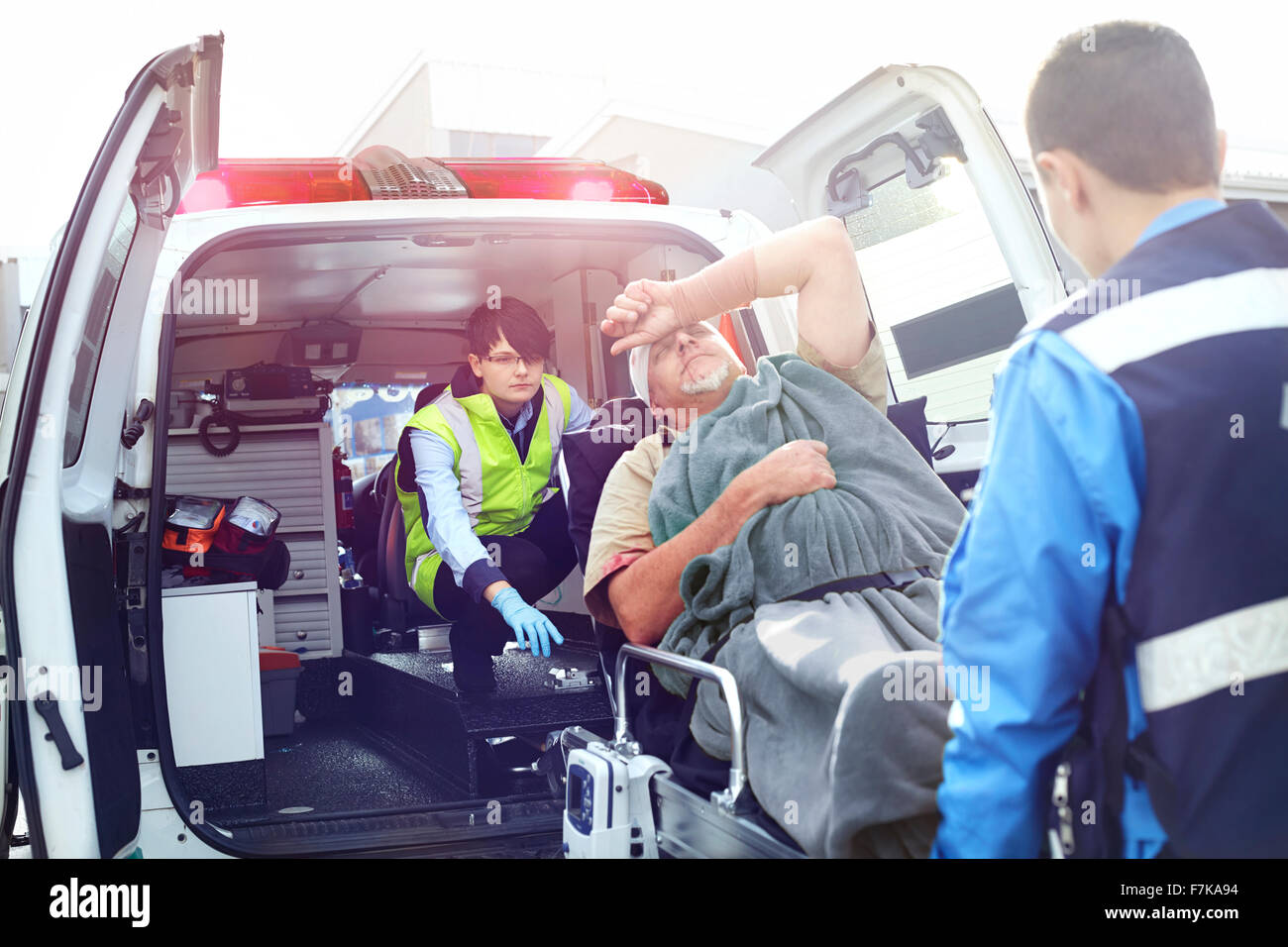 Rescue workers loading car accident victim into back of ambulance Stock Photo